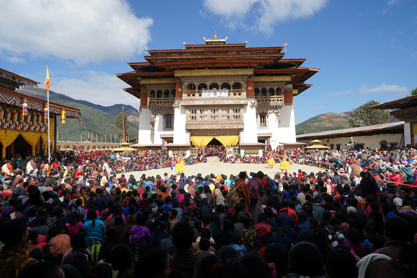 A packed courtyard at Gangtey Goenpa on festival day, dancers in the centre
