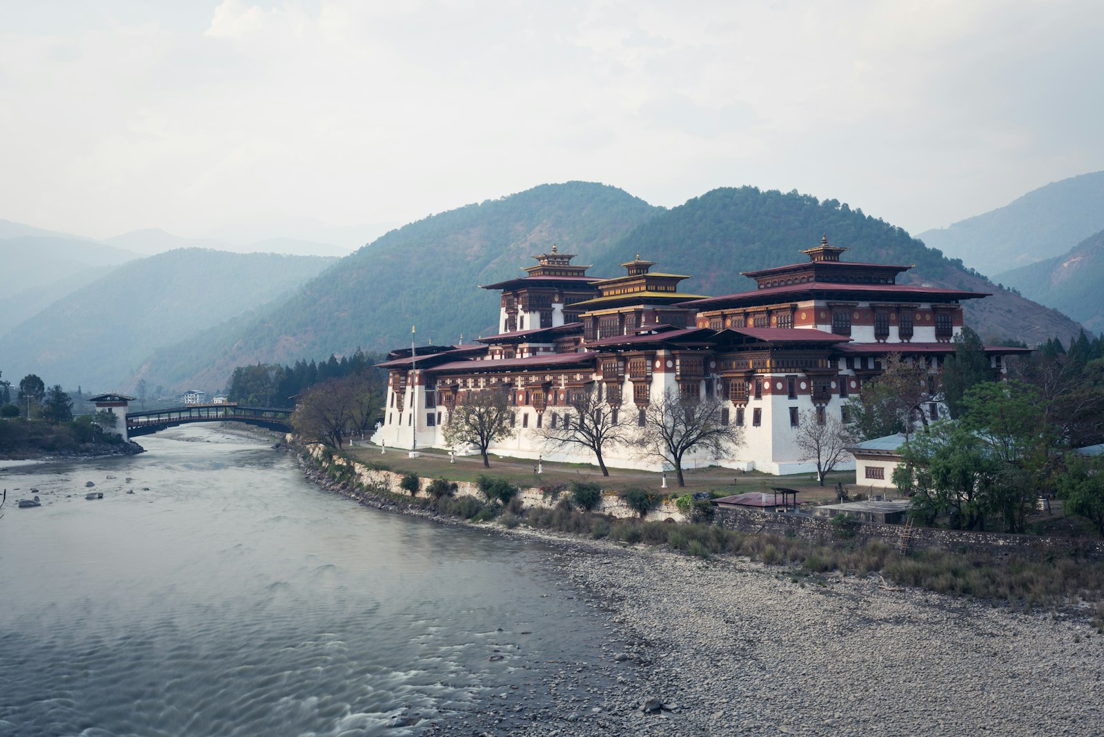 Punakha Dzong seen from the river bed, its cantilever bridge to the left