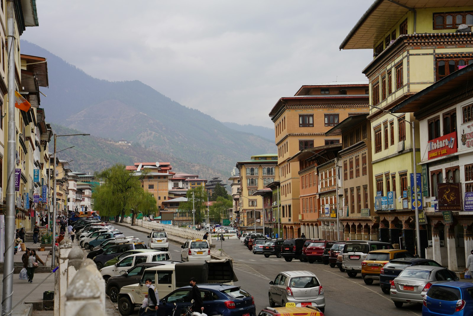 Traffic and shopfronts on a central Thimphu street where cash still matters