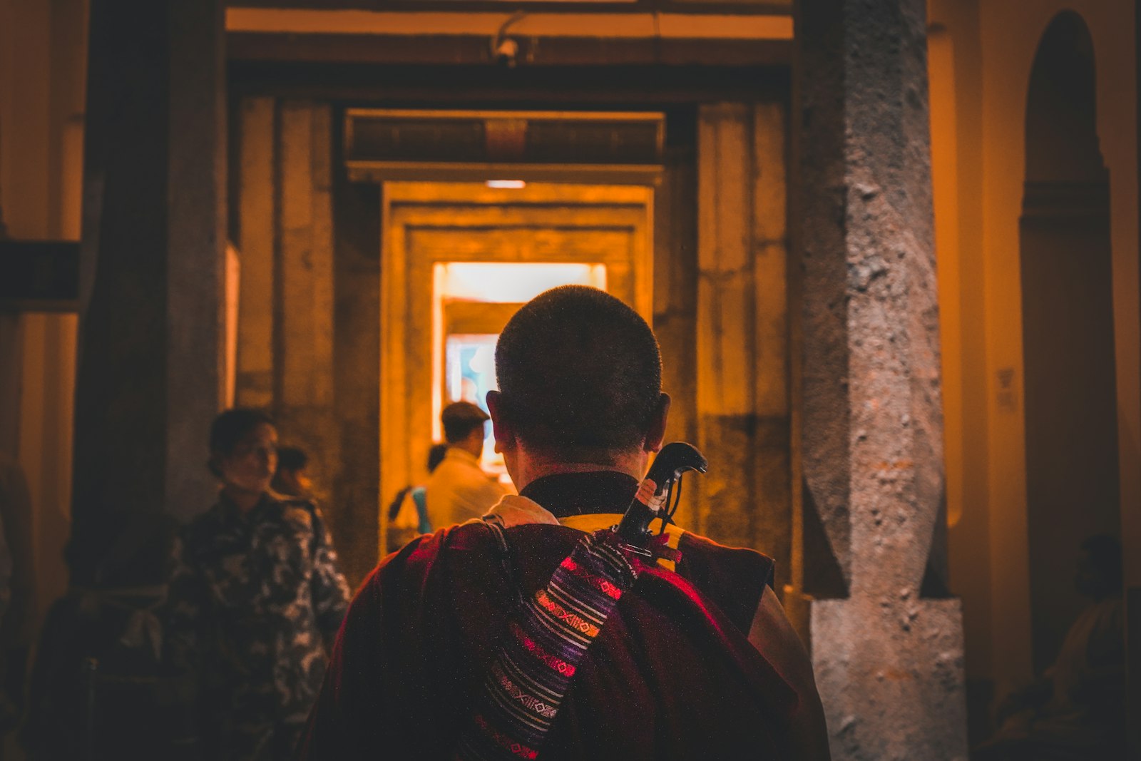 A monk in the lamplit corridor of the Mahabodhi Temple at Bodh Gaya