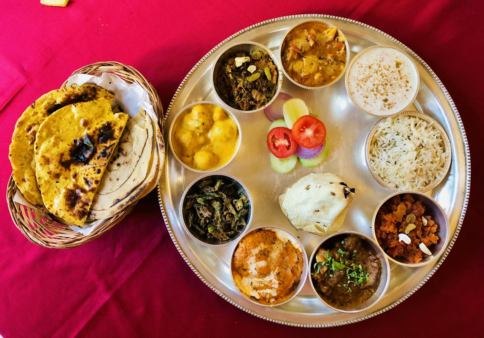 A steel thali of rice, dal, vegetables and breads