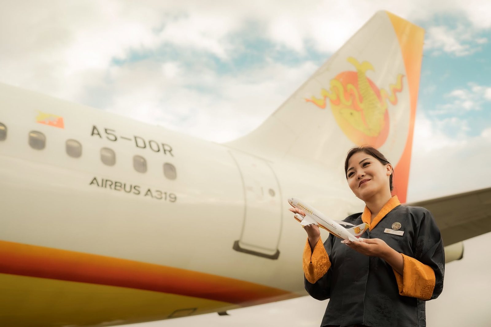 Bhutan Airlines cabin crew beside an A319